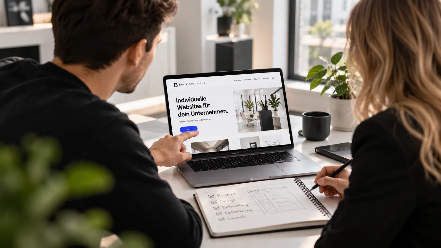 Zwei Personen besprechen am Laptop eine Webseite, im Notizbuch ist abgehakt: Konzept, Design, Entwicklung, Optimierung, Launch